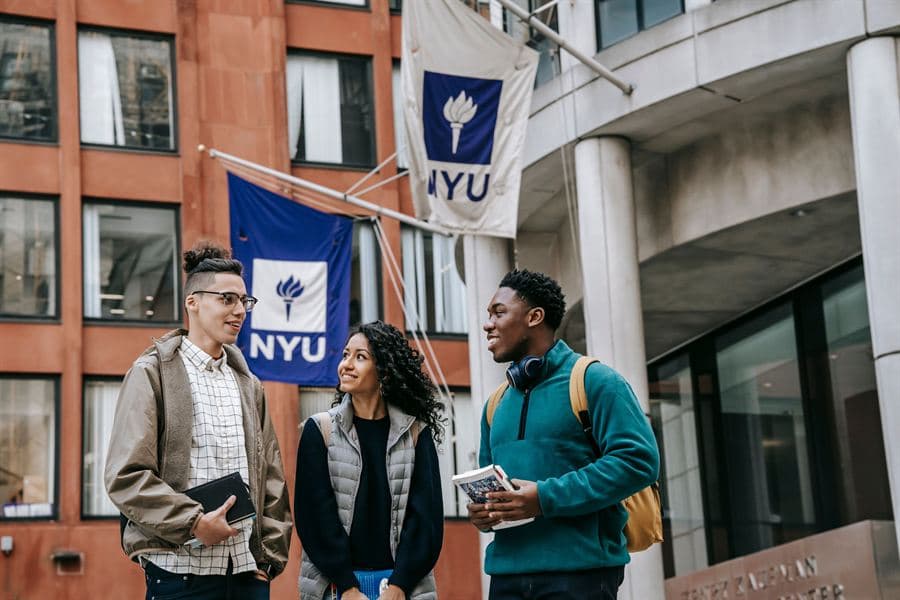 Students walking between buildings on a university campus.